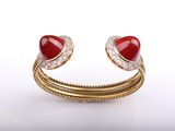 a close up of a red heart shaped ring on a white background