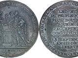 a close up of a silver coin with a picture of people on it