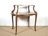 une petite table en bois avec un plateau en verre, posée sur un sol recouvert de moquette