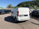 the white van is parked in the parking lot near many other cars