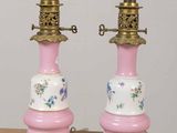 pair of pink and gold lamps with floral designs on them on a table