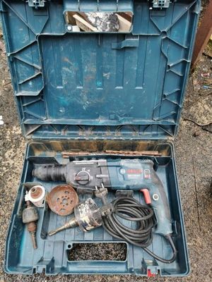 une mallette à outils bleue posée par terre, contenant des outils
