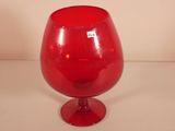 a red glass vase sitting on top of a table