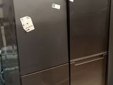 three stainless steel refrigerators are stacked on pallets in a warehouse