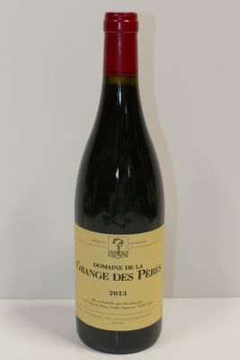 La bouteille de vin rouge est posée sur une table blanche.