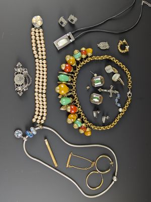 Plusieurs bijoux différents sont disposés sur une surface noire
