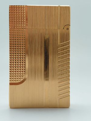 un briquet plaqué or posé sur une surface blanche