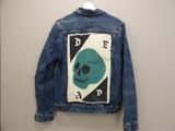 denim jacket with a skull patch on the back of the jacket
