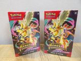 deux boîtes de cartes à collectionner Pokémon posées sur une table