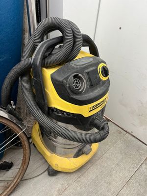 a yellow and black vacuum sitting next to a blue door