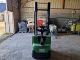 un chariot élévateur vert garé dans un garage