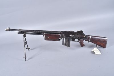 un pistolet ancien posé sur un trépied, sur une surface blanche