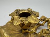 a gold vase with a bird on it on a table