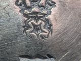 a close up of a metal plate with a crown on it