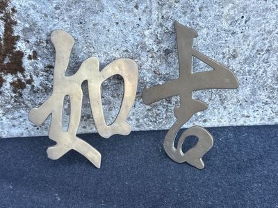 two metal letters that are sitting next to each other on a blue surface