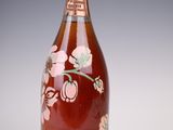 an image of a bottle of wine with a pink flower on it