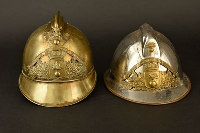 une paire de casques en laiton avec crête et bouclier, superposés l'un sur l'autre