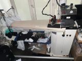 une table à repasser posée sur une table dans une pièce encombrée