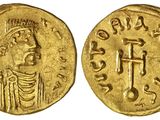 une pièce d'or avec l'image d'un homme tenant une croix