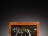 a bronze plaque of a lion on a wooden stand
