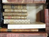 books are stacked on top of each other on a shelf