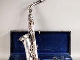 un vieux saxophone argenté dans un étui bleu sur fond blanc