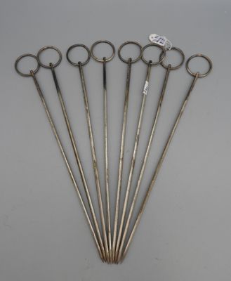 six pairs of antique scissors are arranged in a row on a table
