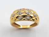gros plan d'une bague en or avec des diamants sur fond blanc