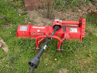 a red machine that is sitting in the grass