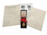 une médaille d'or dans un coffret noir orné d'un ruban rouge