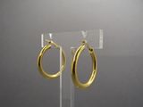 pair of gold hoop earrings on clear acrylic stand