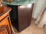 une petite table avec un plateau en verre, dans un coin de la pièce