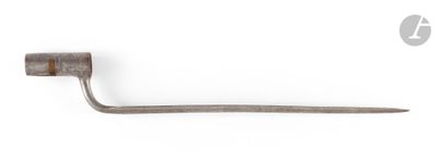 a small metal object with a long handle on a white surface