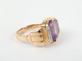 a close up of a gold ring with an amethorate and diamonds