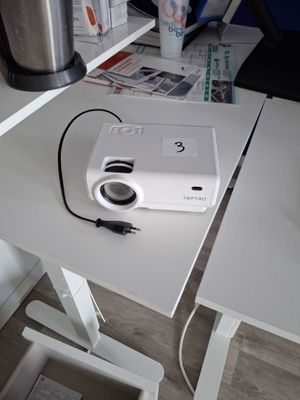 a white projector sitting on a white desk