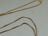 a close up of a gold necklace with a chain attached to it