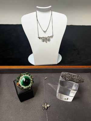 une vitrine dans laquelle sont exposés un collier, un bracelet et d'autres bijoux