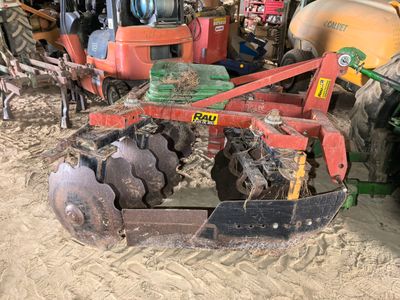 a tractor with a plow attached to it in the dirt