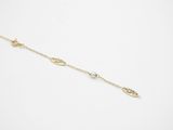 a gold ankle chain with a leaf charm on a white background