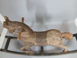 a wooden rocking horse that is sitting on a stand