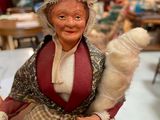 a figurine of a woman in a dress and bonnet holding a cotton ball