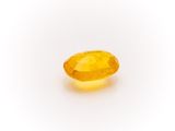 a yellow sapphire stone on a white background
