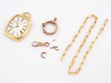 an assortment of gold jewelry including a watch, chain, and other items