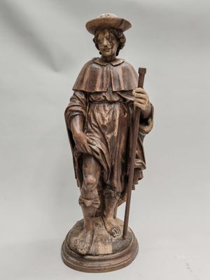 a wooden statue of a man with a hat and a cane