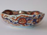 a small bowl with a design on it on a white surface