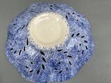 a blue and white bowl with black dots on it
