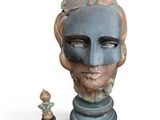 a statue of a man with a mask next to a chess piece