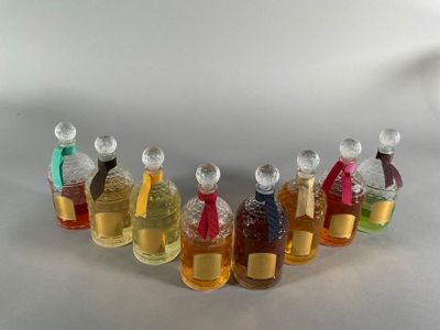 many different colored bottles of perfume on a white surface