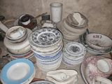 a lot of plates and bowls sitting on the floor