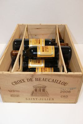 plusieurs bouteilles de vin se trouvent dans un coffret en bois sur une table